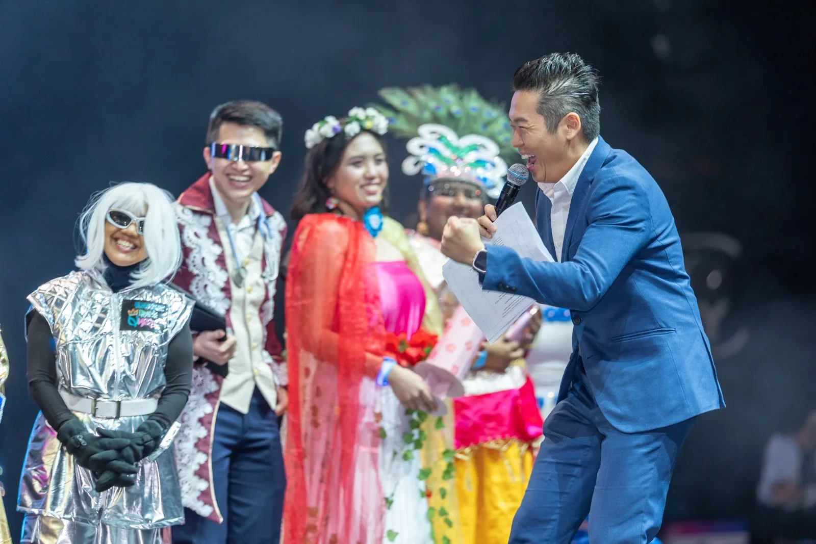 James Yang with guests in costume on stage at a dinner and dance